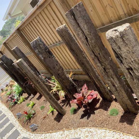 Upright timber sleeper posts in garden showing an example of creative landscape designs.