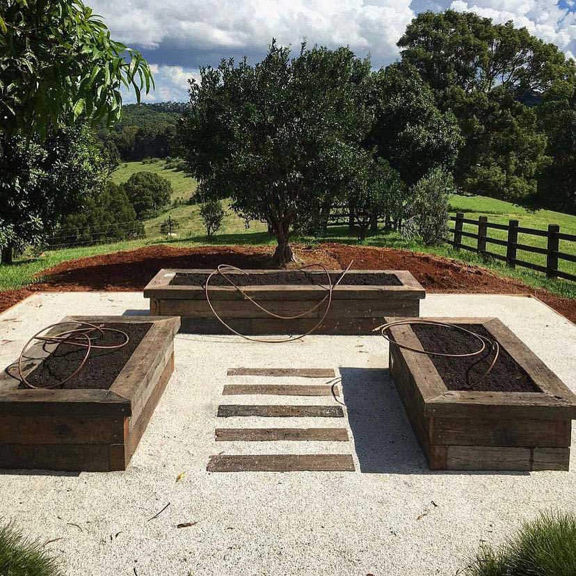 Outdoor garden featuring three raised garden beds made from Off The Rails Byron Bay reclaimed timber sleepers
