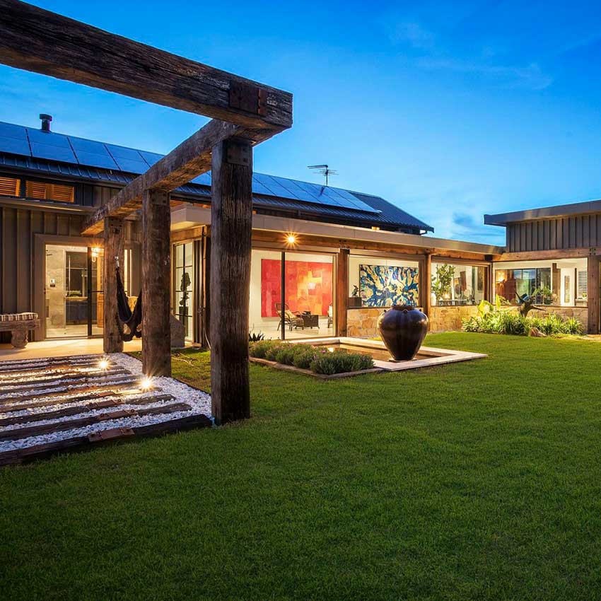 Image of reclaimed timber pathway, lush green lawn and outdoor water feature.