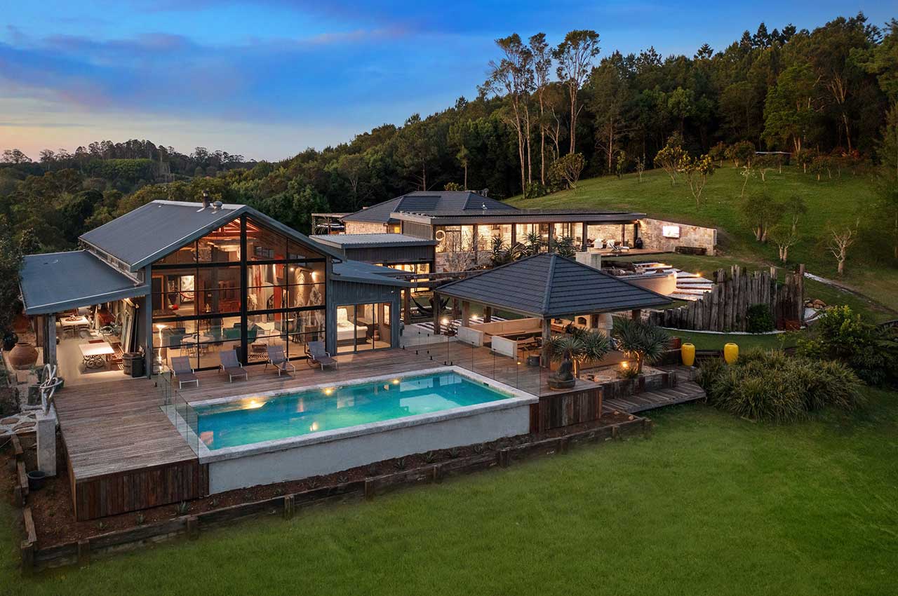 View of property from an elevated angle, showcasing a large timber deck and pool.